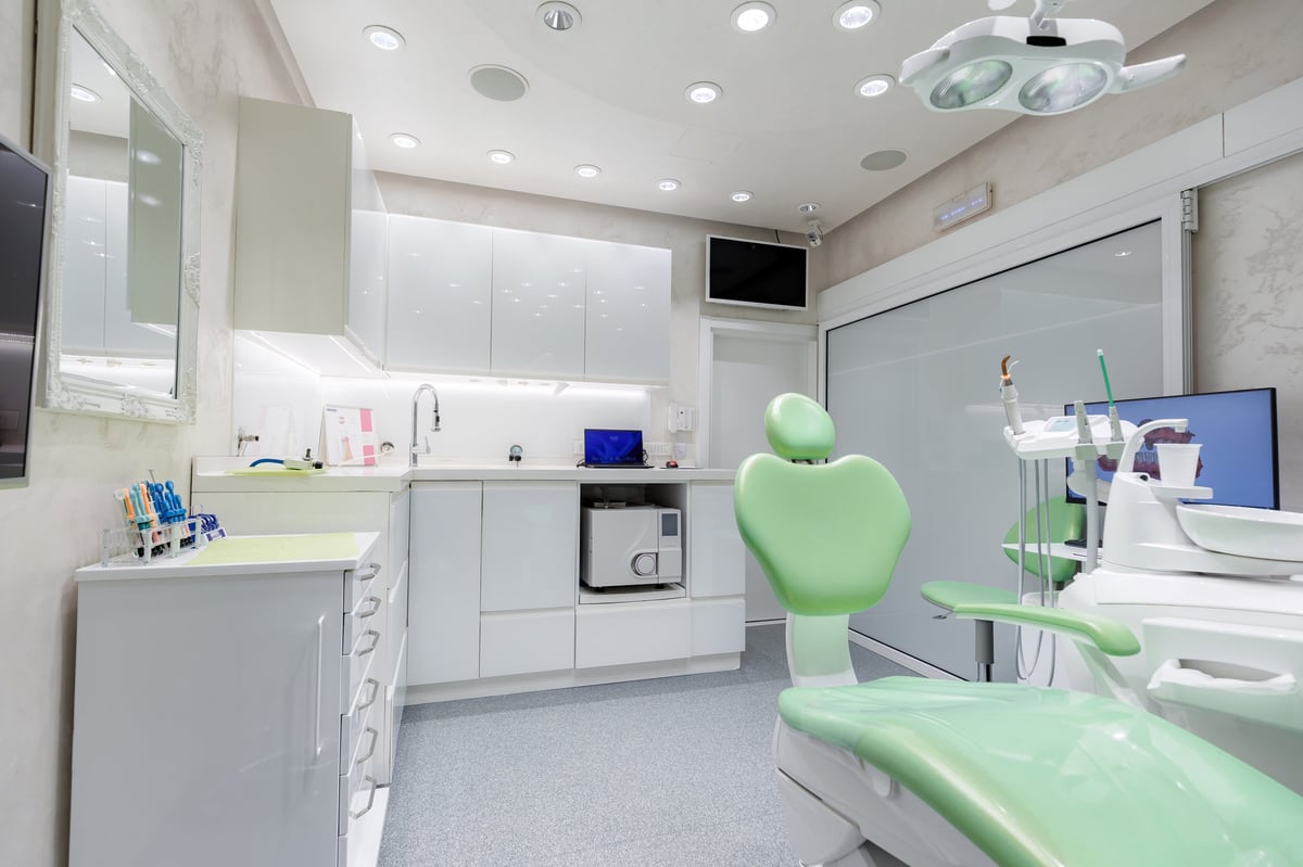 Modern bright dental office with green chair and advanced equipment